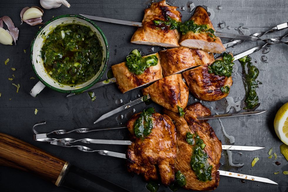 barbequed chicken breast skewers with chimichurri sauce  on gray background ready to eat