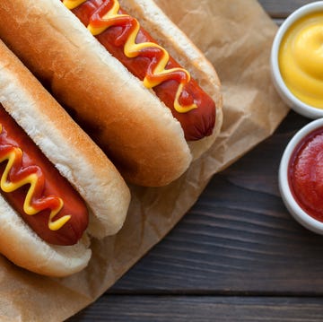 Barbecue Grilled Hot Dog with Yellow Mustard and ketchup on wooden table Barbecue Grilled Hot Dog with Yellow Mustard and ketchup on wooden table