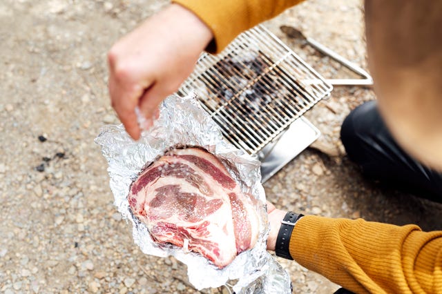 barbecue man putting salt on meat
