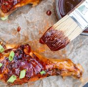 brushing barbecue sauce on chicken wings