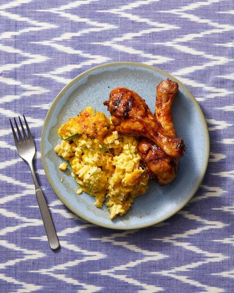 barbecued chicken with roasted corn pudding on a blue plate