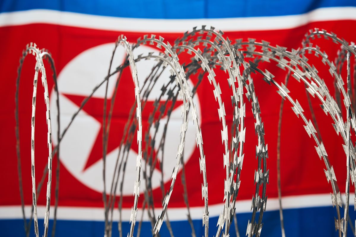 Barbed wire and North Korean national flag DPRK