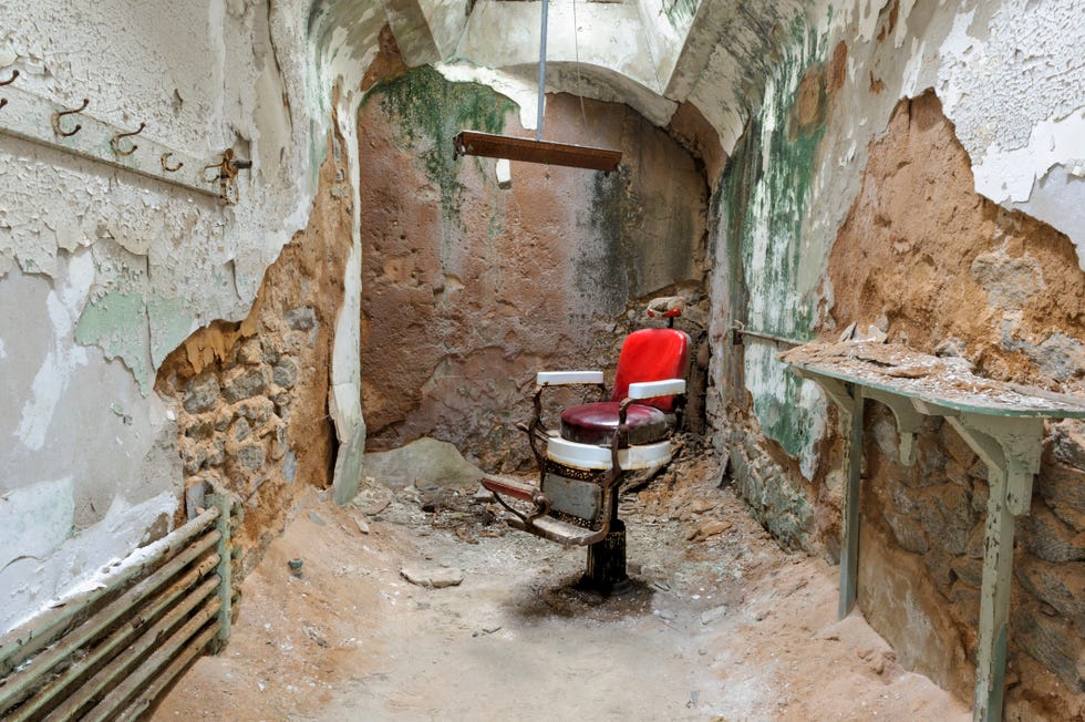 barber chair in empty prison cell ruins, eastern state penitentiary