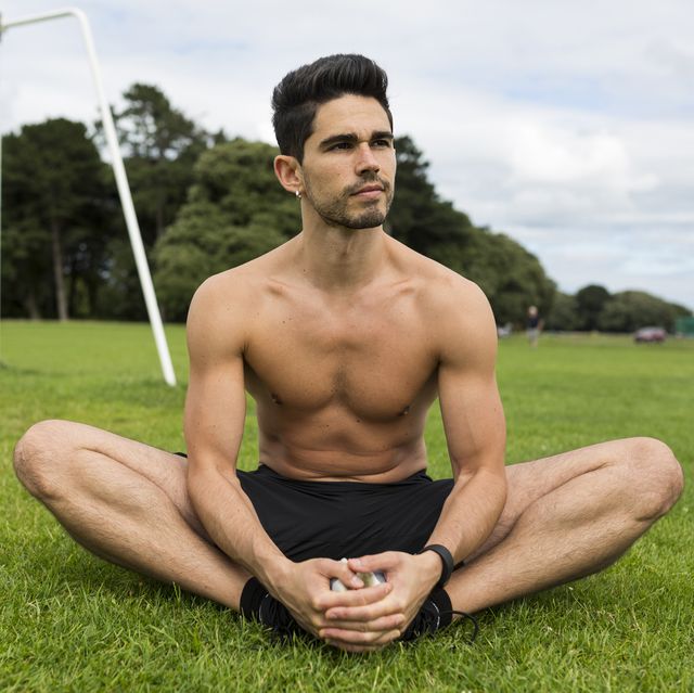 Barechested athlete sitting in grass