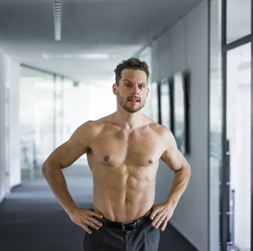 barechested businessman standing in office