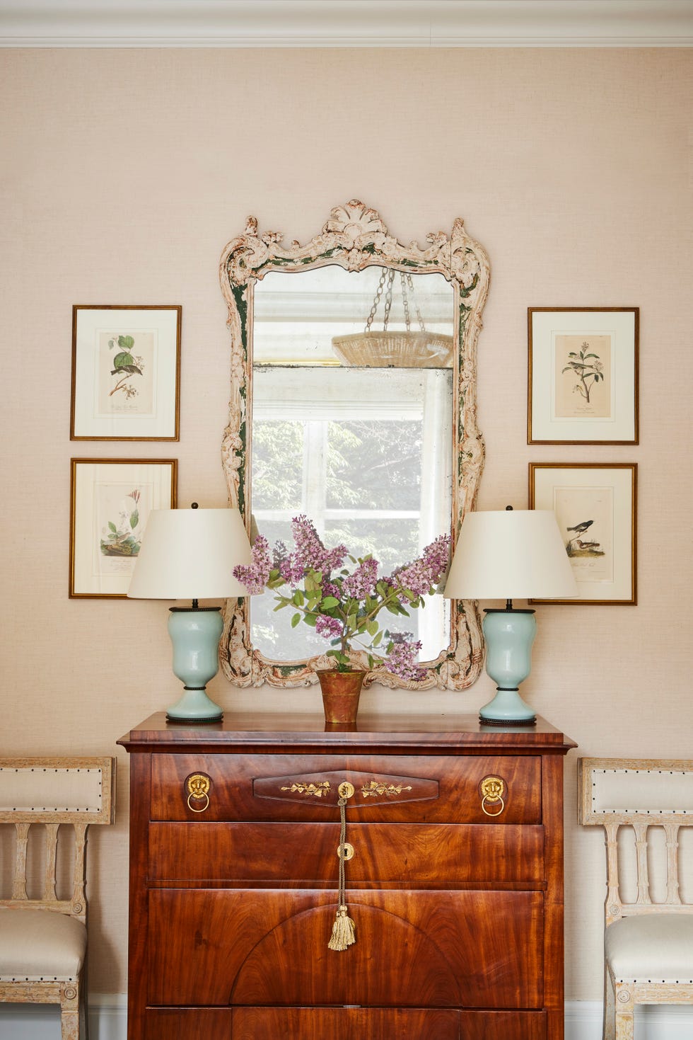 audubon prints hang around a mirror and above a wood antique dresser