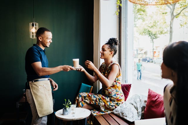 barista serveert koffie aan vrouw