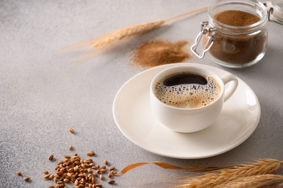 barley coffee in white cup and ears of barley on gray background