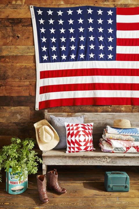 american flag hanging above a chippy bench in a barnwood covered entryway