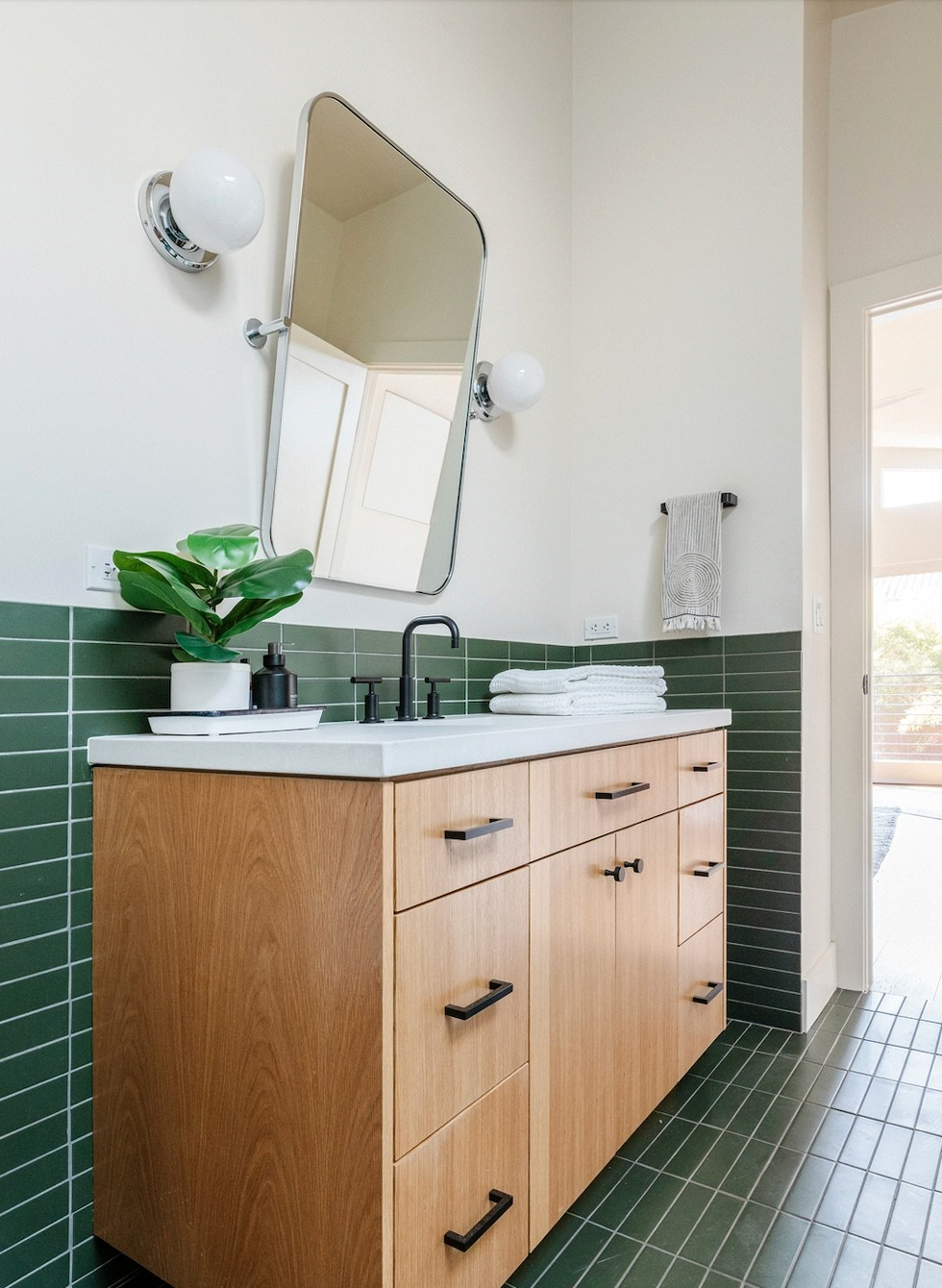 modern bathroom vanity with sink mirror and green tiled walls