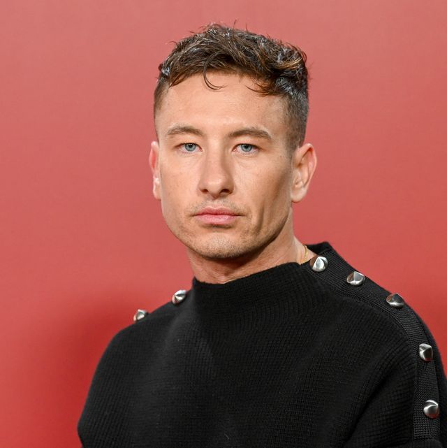 actor barry keoghan posing for a photo in front of a red backdrop