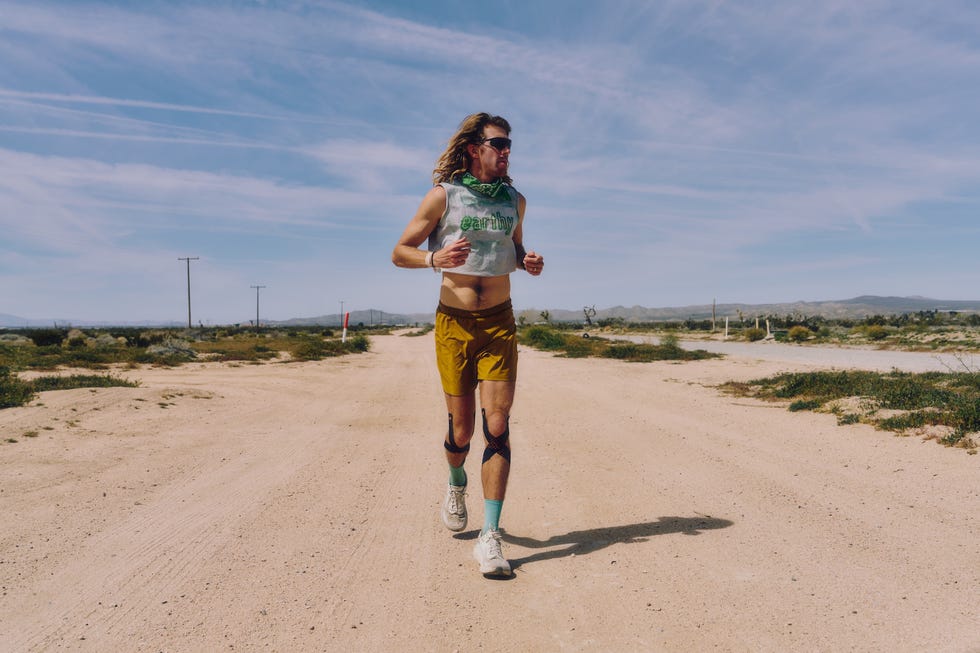 individual running on a dirt road in a desertlike environment