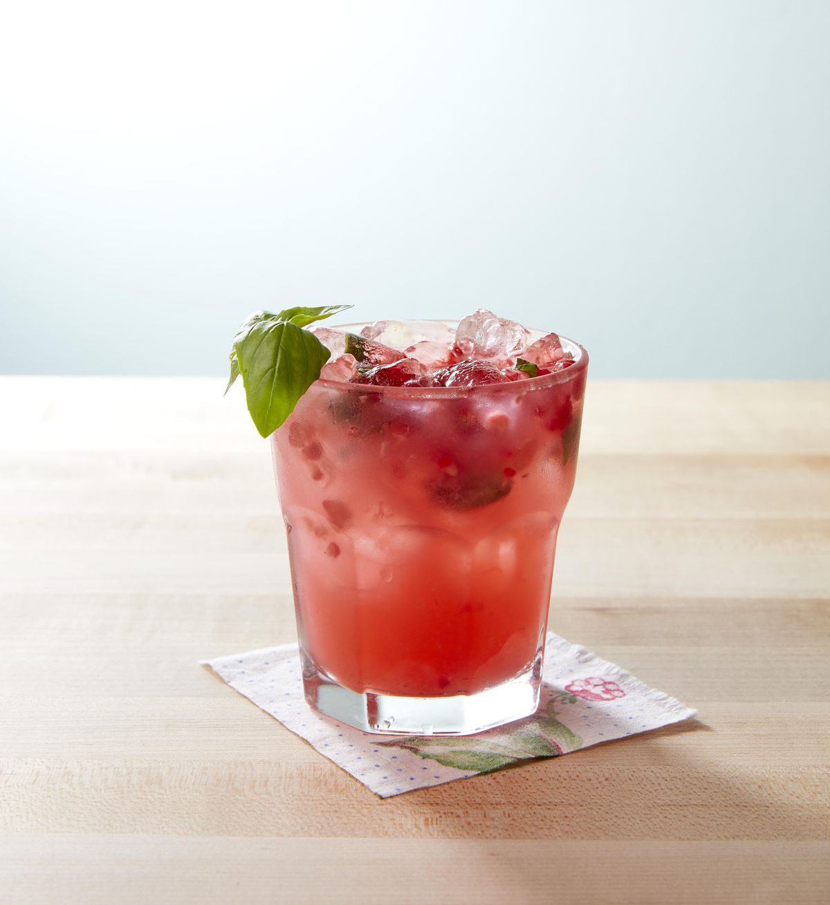 basil raspberry lemonade garnished with a basil sprig