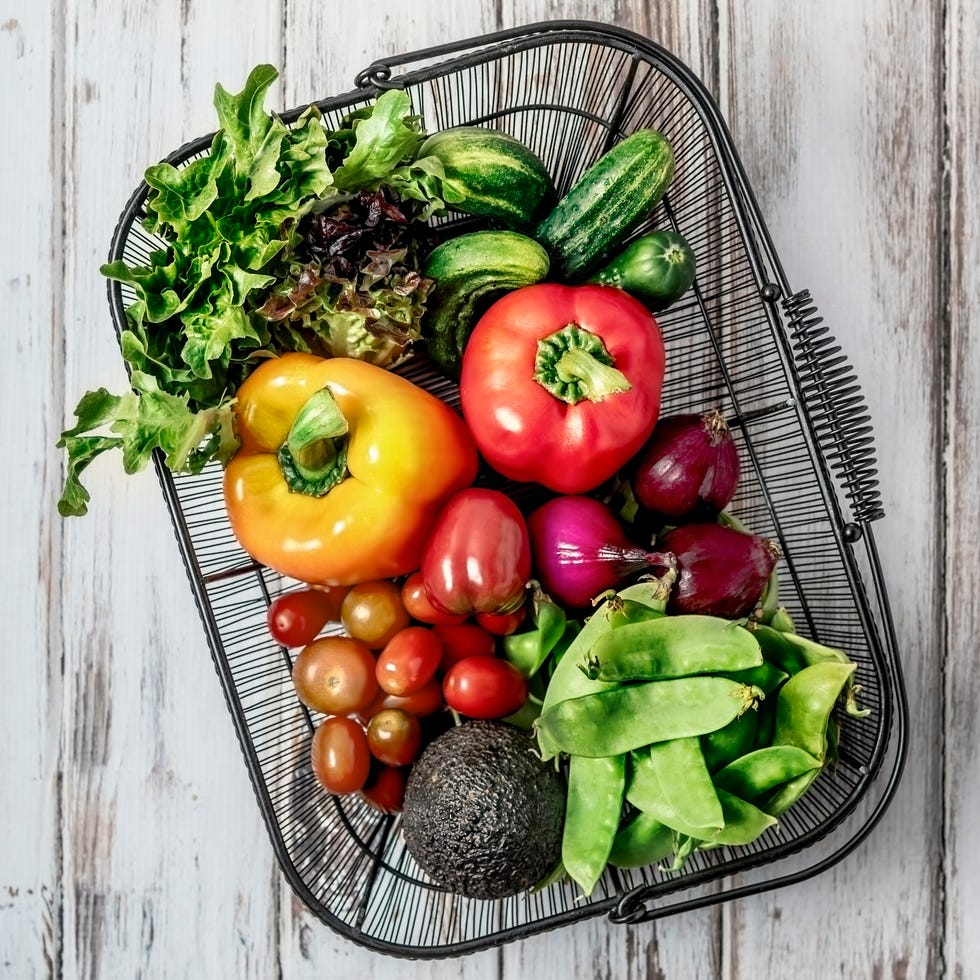 a basket of fresh fruits and vegetables on white background