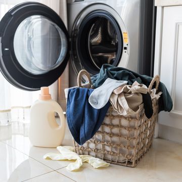 basket with laundry and washing machine