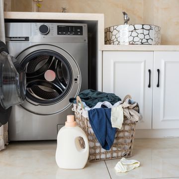 basket with laundry and washing machine