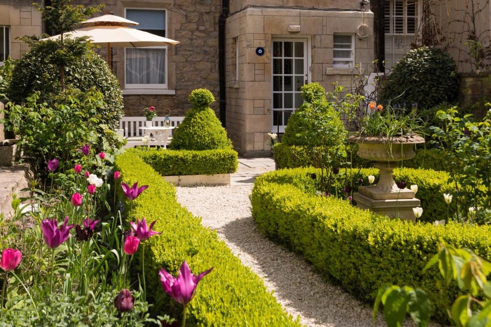 a garden with a fountain and flowers