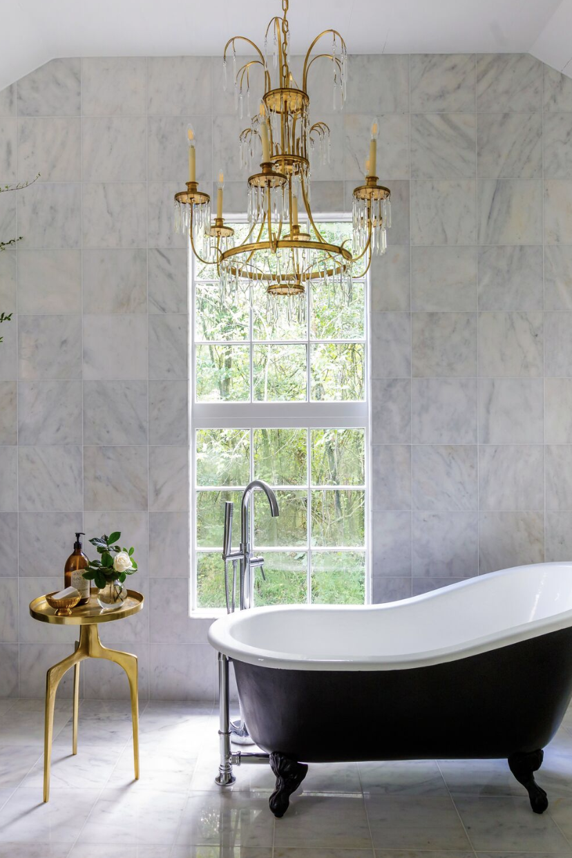 bathroom with freestanding tub and gold chandelier