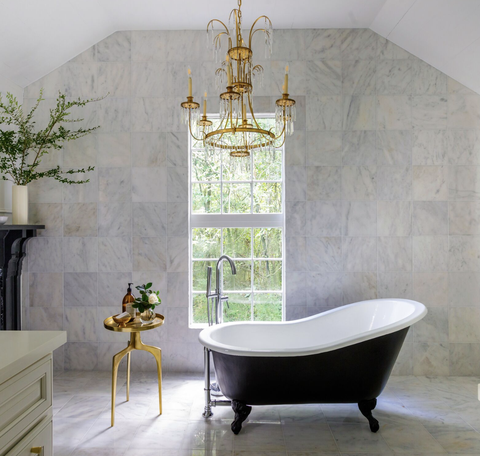 bathroom with freestanding tub and gold chandelier