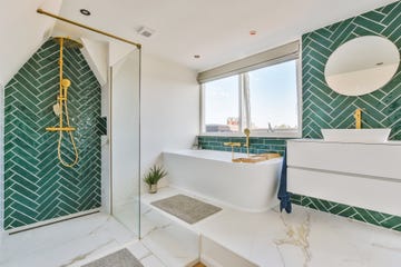 the interior of a bathroom decorated with marble and gold colored equipment in a modern house