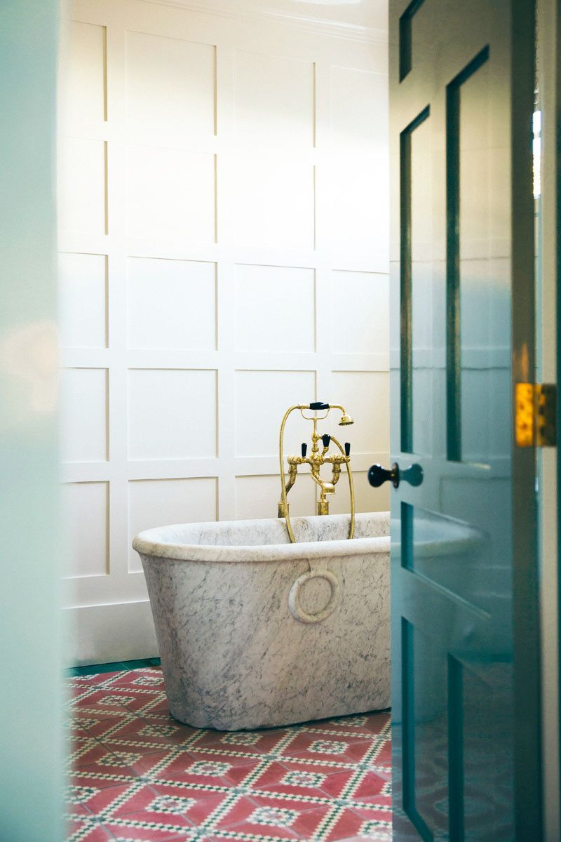 Contemporary tiled bathroom in Italian villa with marble bathtub