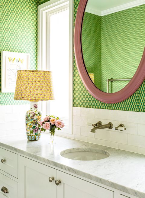 bathroom with green wallpaper and colorful table lamp