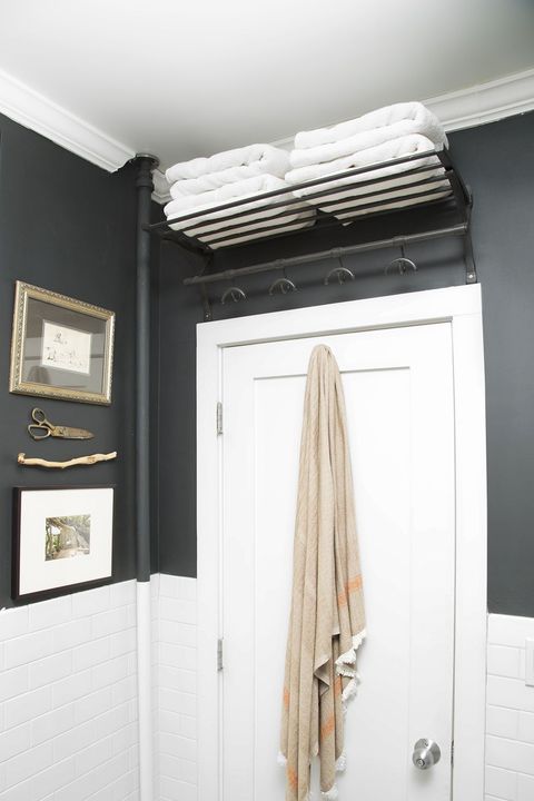 bathroom organization ideas, towel hanging behind a white bathroom door, with shelf space at the top