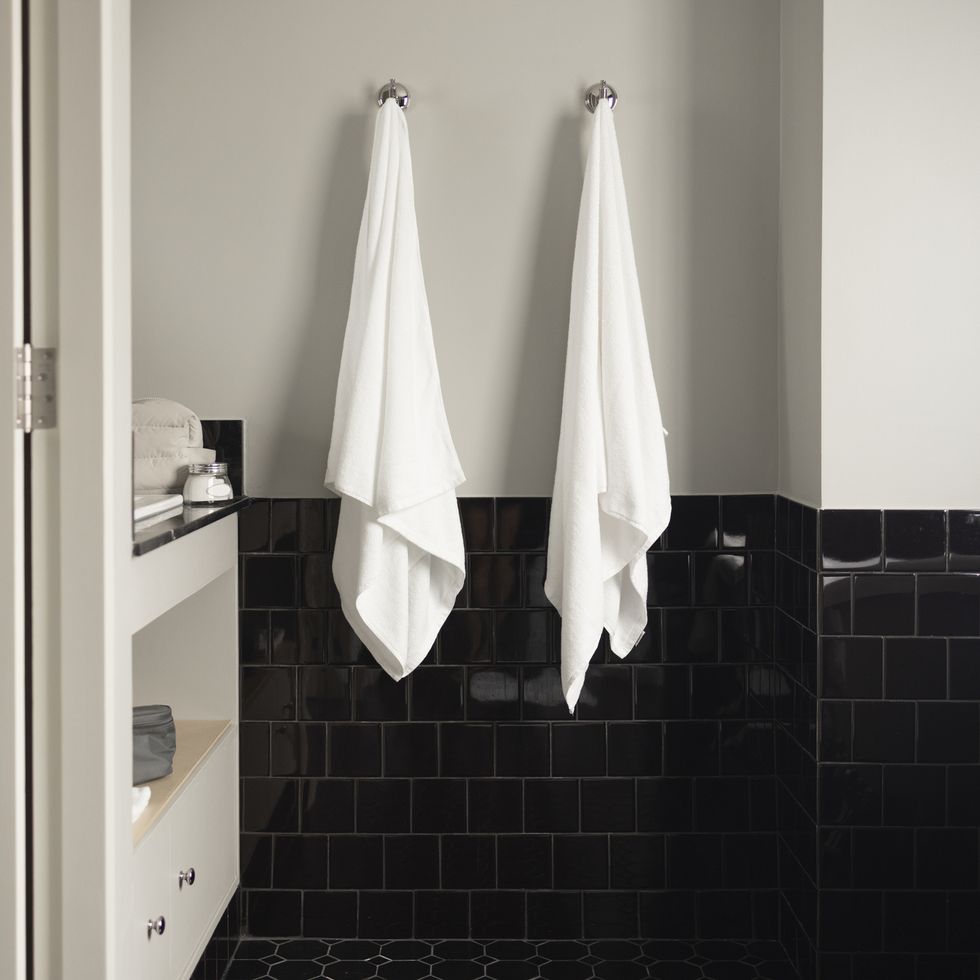 bathroom organization ideas, two white towels hanging on the wall using hooks