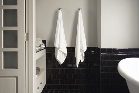 bathroom organization ideas, two white towels hanging on the wall using hooks
