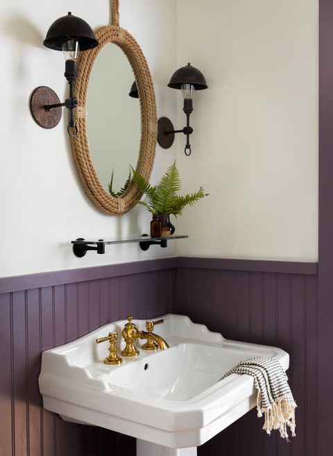 small purple bathroom with shelf above sink