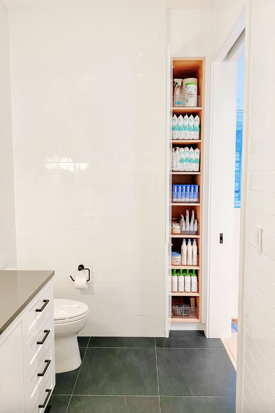 bathroom storage ideas, thin cabinet open to reveal bath products