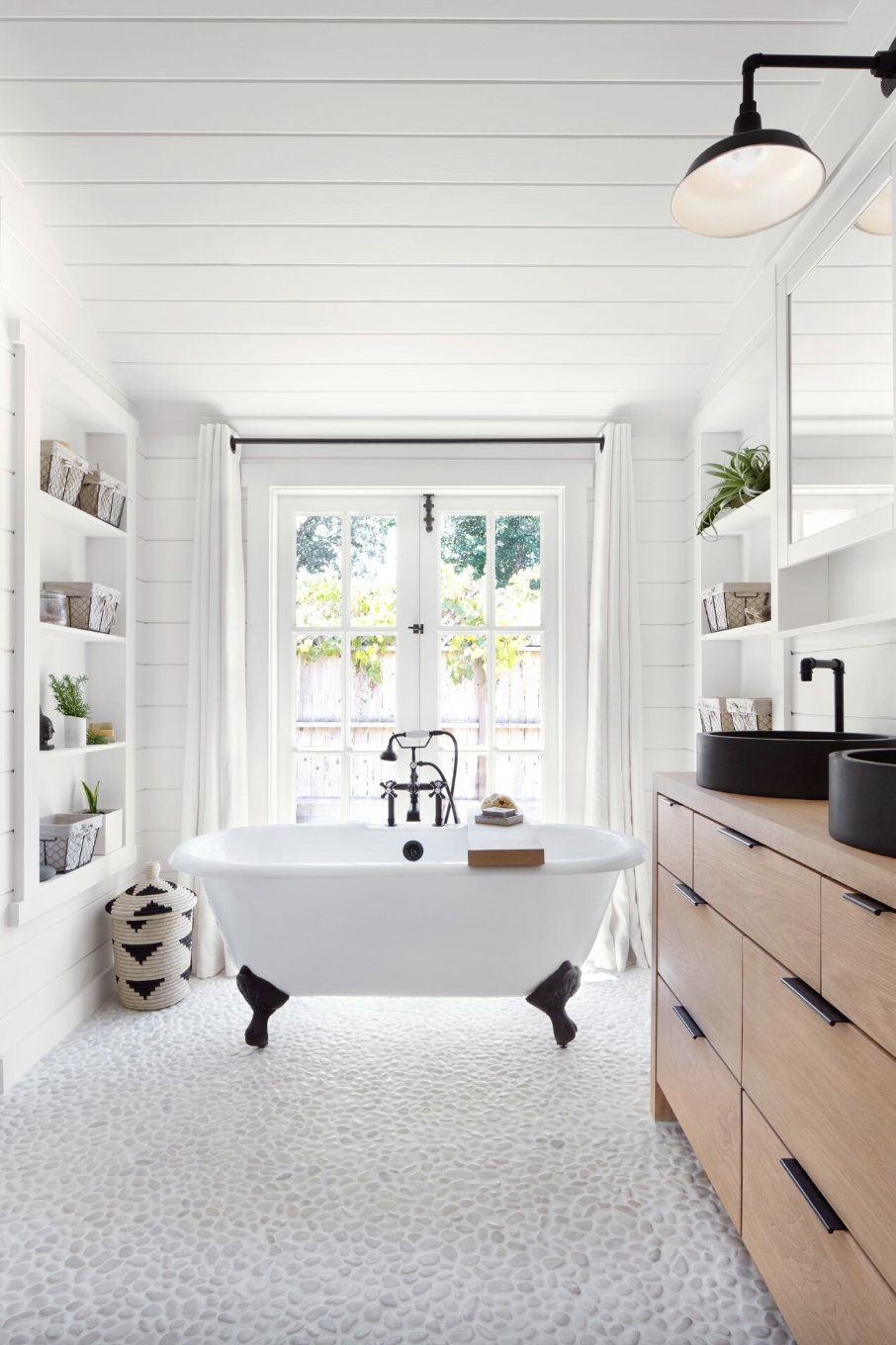 bathroom storage ideas, built in open shelves on both sides of a large white bathroom with a tub in the center