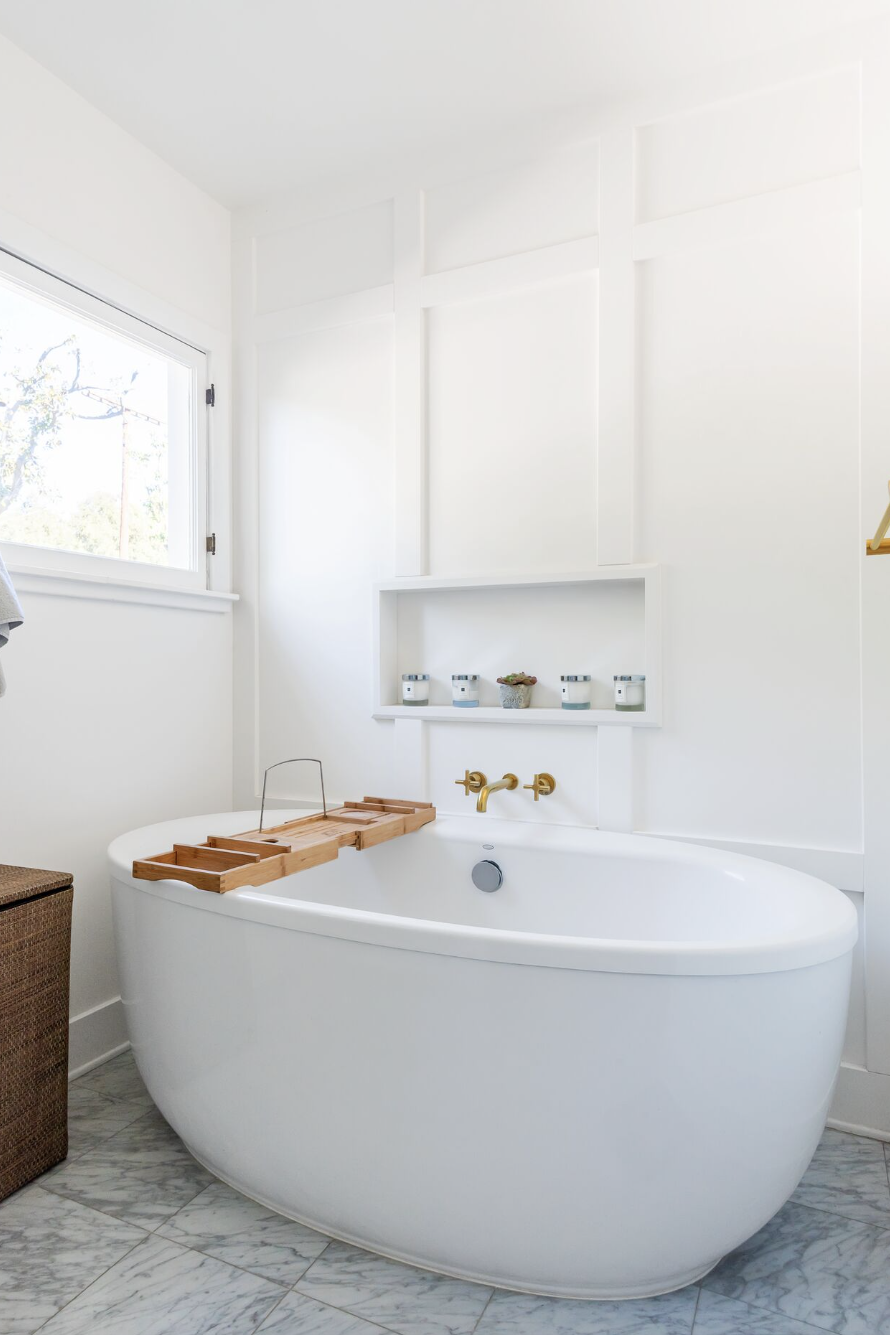 bathroom storage ideas, white tub with a bath caddy and alcove in the wall beside it