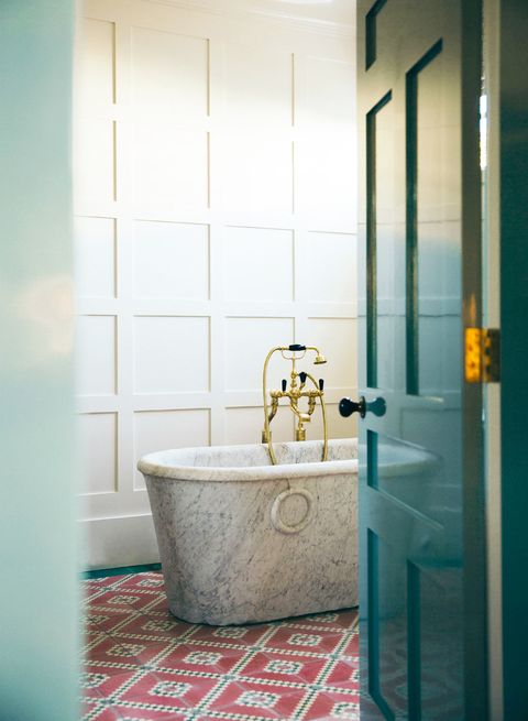 formal bathroom with freestanding marble tub and tile floor