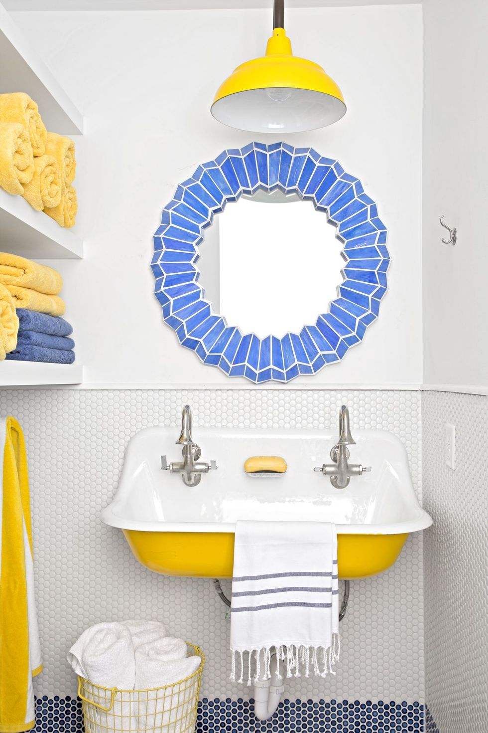 white penny tile lower bathroom wall with band of blue at bottom, yellow vintage sink and pendant light, blue tile mirror