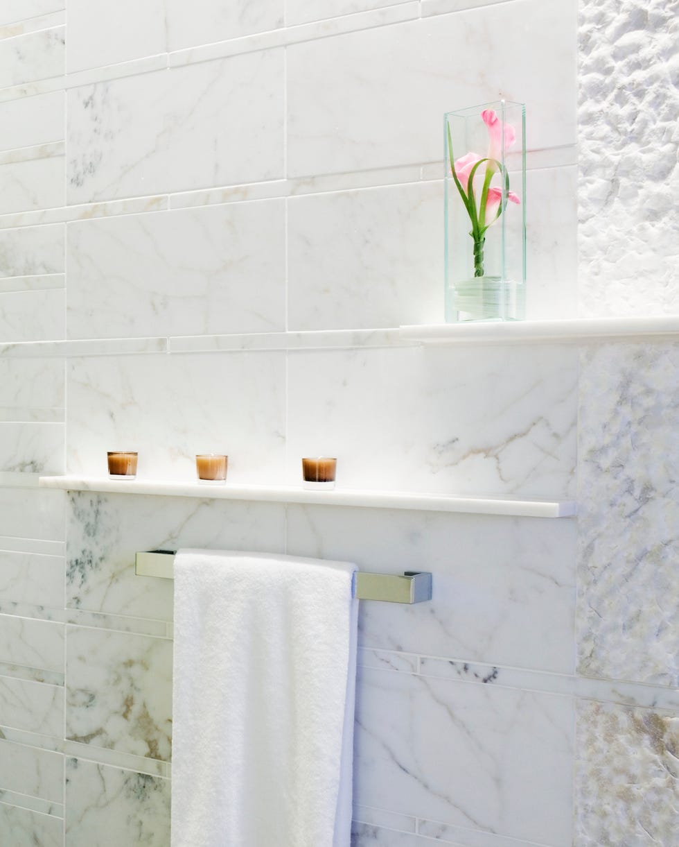 Bathroom Wall bathroom wall with two streamlined and low profile shelves that hold candles and a flower