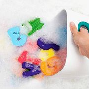 hand scooping up foam bath toys from sudsy bathtub with white and teal bathtub organizer