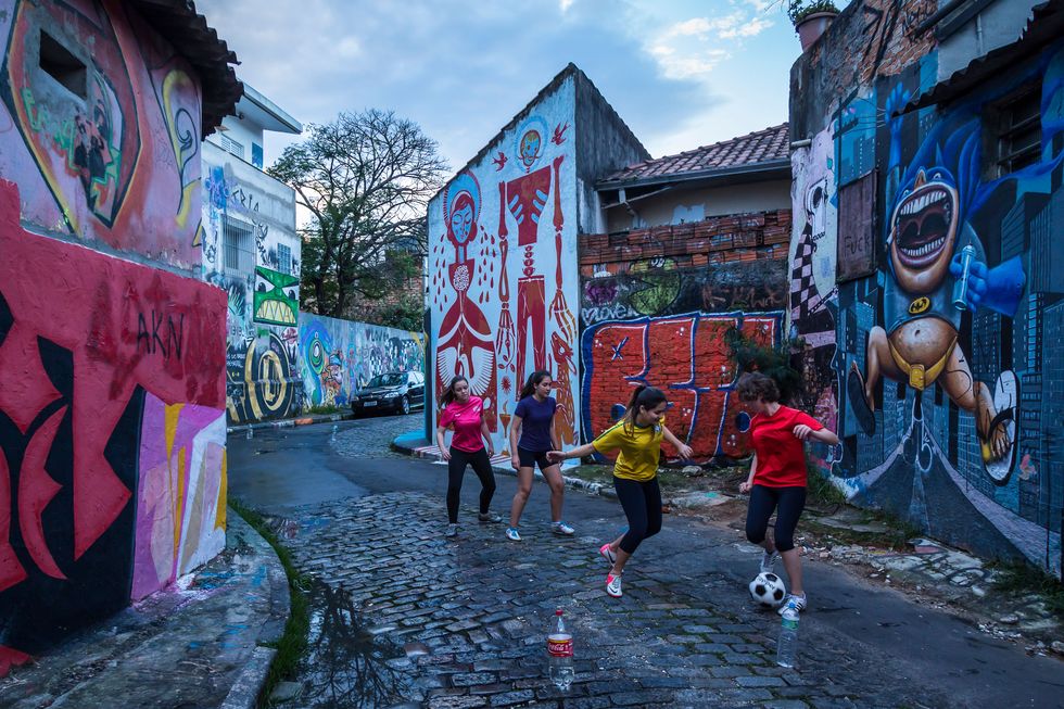 a group of young women play a "pelada", a kickabout in a graffiti covered walled, cobbled street known as the "beco do batman", batman alley in vila madalena, sao paulo city photo by christopher pillitzgetty images