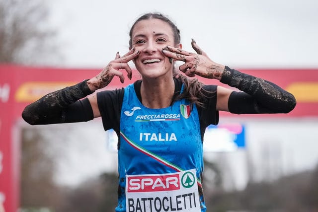 a muddy athlete celebrating after a competition