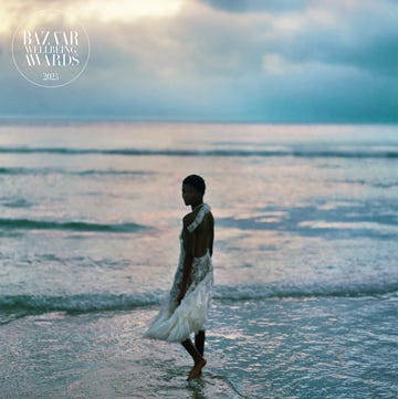 person in a white dress walking on the beach at sunset person in a white dress walking on the beach at sunset