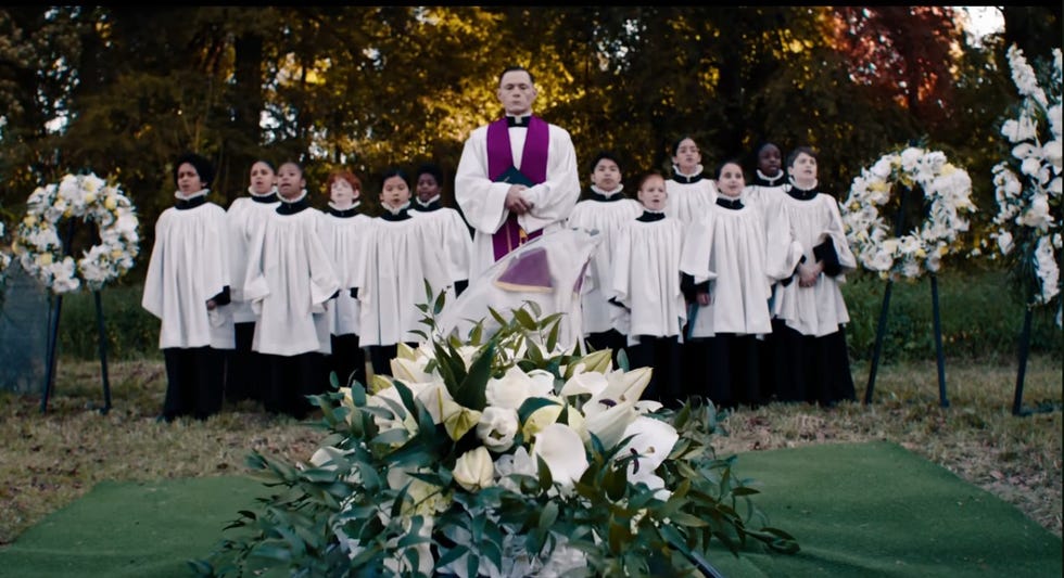 a church choir sings at a funeral in a scene from beetlejuice