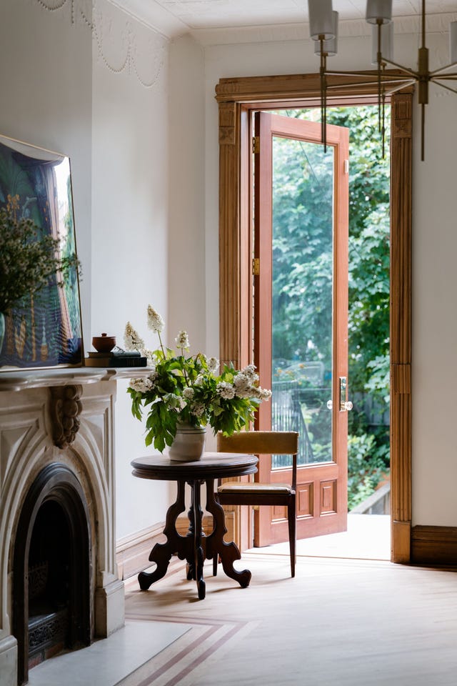 a room with a fireplace and a table with a plant on it