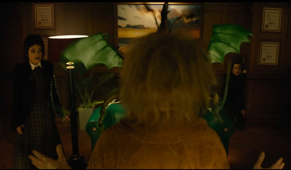 beetlejuice stands in front of a shrunkenheaded bob, smirking, in a scene from beetlejuice beetlejuice beetlejuice