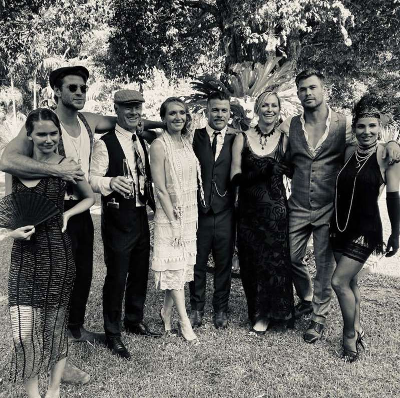 chris hemsworth standing with his family in a black and white photo, featuring liam and his new girlfriend gabriella