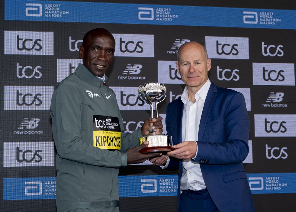 eliud kipchoge being presented with a trophy