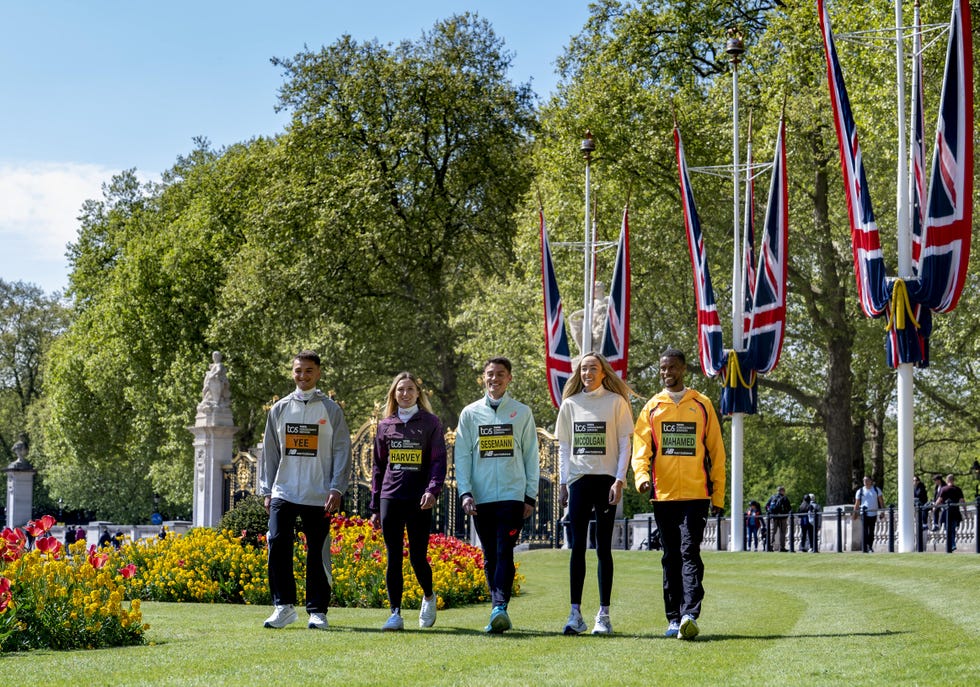 a group of five smiling runners walking through st james's park