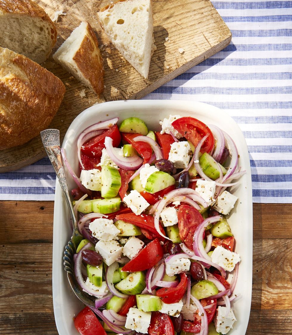 greek tomato and feta salad in a serving dish with a spoon