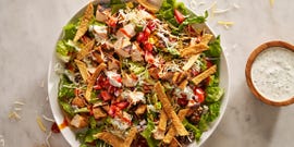 bbq chicken salad with barbecue sauce, chicken, toppings, and a creamy dressing