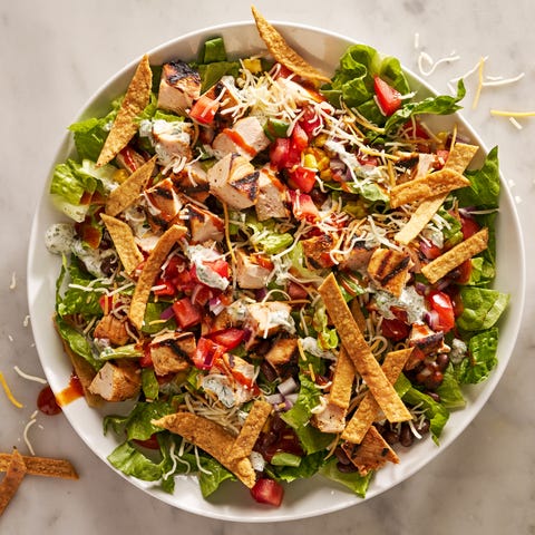 bbq chicken salad with barbecue sauce, chicken, toppings, and a creamy dressing