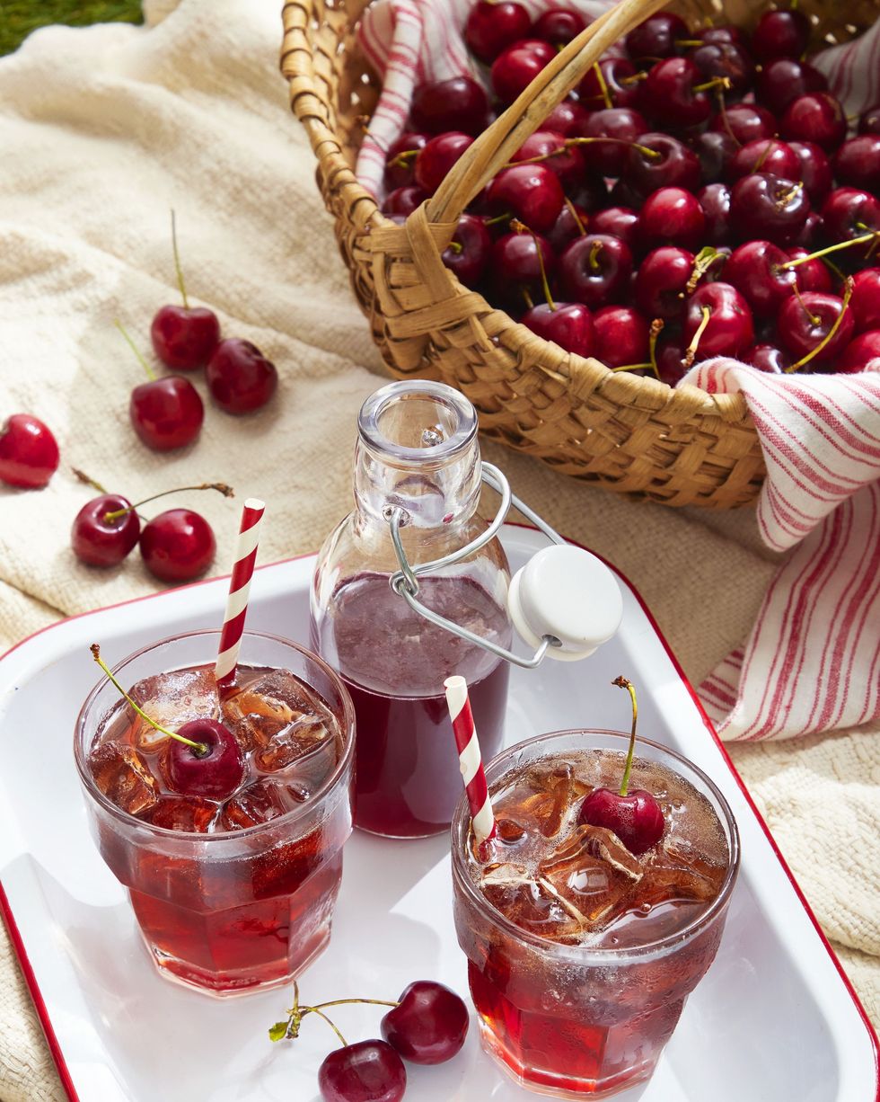 cherry syrup and rum soda in glasses with ice and fresh cherries for garnish
